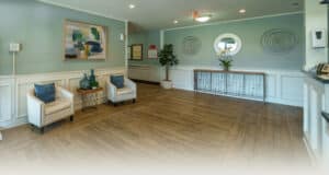 The lobby area with wood floors, comfortable chairs to sit in, and wall decor